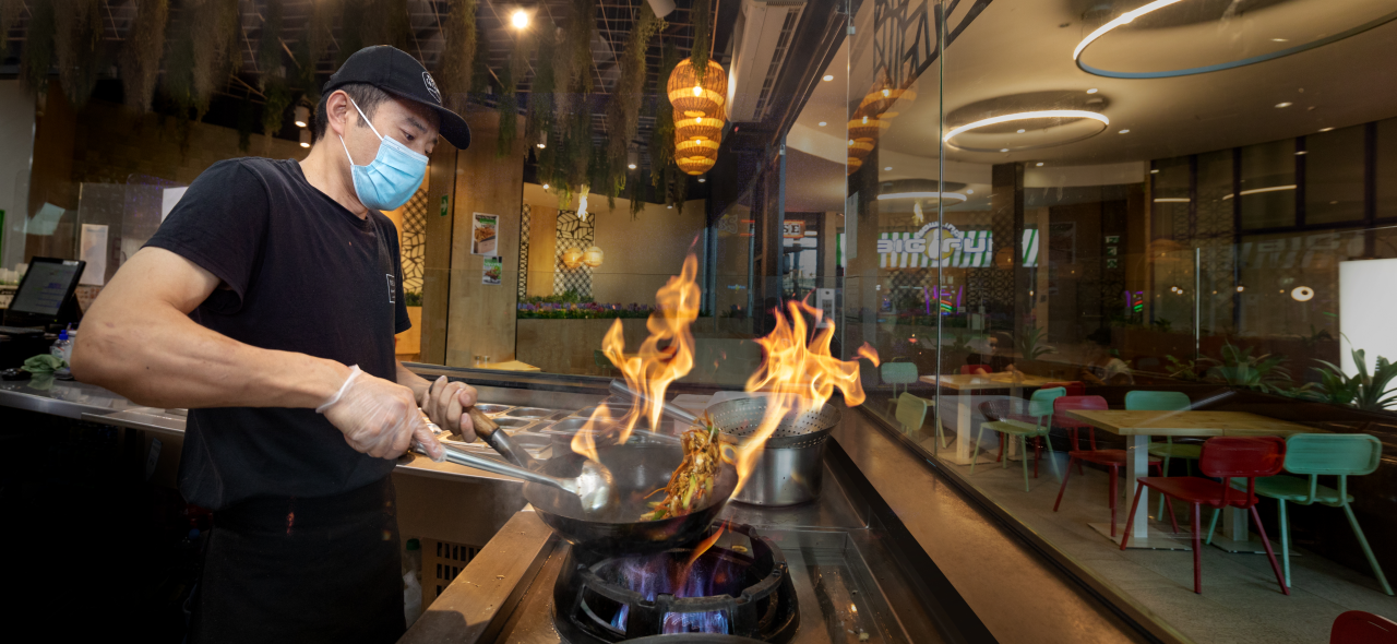 Cocinero de Pure Cuisine preparando wok